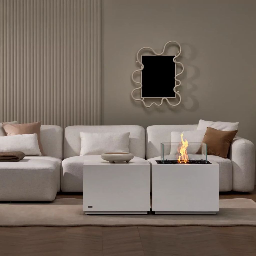 Compact fire table in a bone finish placed in a soft neutral living room