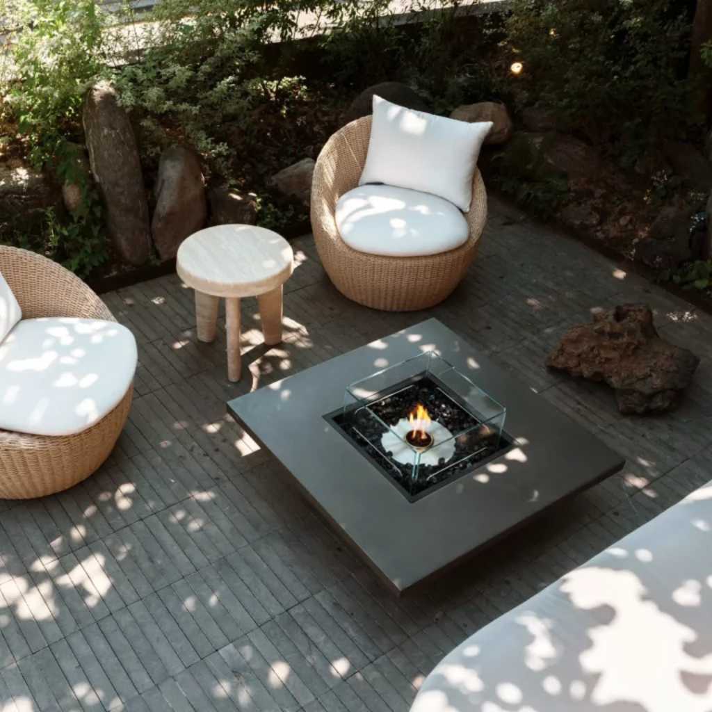 Cozy outdoor setup with drinks arranged around a square concrete centerpiece.
